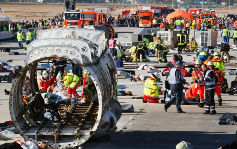 Helfer, als Verletzte verkleidete Freiwillige und Teile von Flugzeugen liegen auf der im Bau befindlichen Nordwest-Landebahn des Flughafens in Frankfurt am Main bei der bisher größten Katastrophenschutzübung in Deutschland (09.10.2010). Foto: dpa