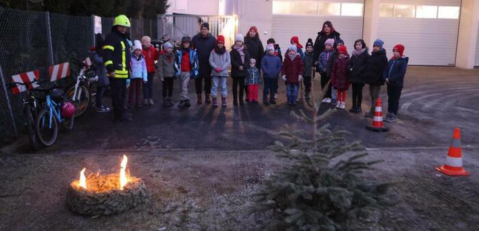 Andreas Lenz (l.) zeigt den Kindern der Mini-Feuerwehr anhand des brennenden Kranzes, was genau zu tun ist. FOTO: maik reuss