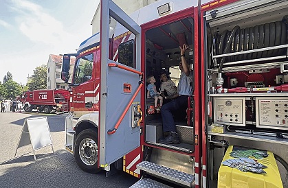 Infraserv-Feuerwehrmann Peter Becker zeigt den Unterliederbacher Brüdern Aaron und Franz Hertel das Einsatzfahrzeug.